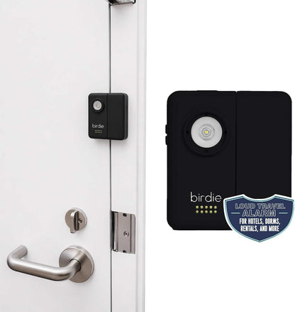 Birdie door alarm in black shown installed on a white door's edge near a lever handle, plus a close-up view showing the circular light\/flashlight lens and dot indicators. Badge reads 'Loud Travel Alarm for Hotels, Dorms, Rentals, and More'.