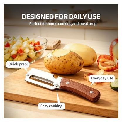 A vegetable peeler with a dark wood handle and silver stainless steel blade rests on a wooden cutting board beside a partially peeled potato and apple peels. A glass bowl of diced fruit sits in the background.